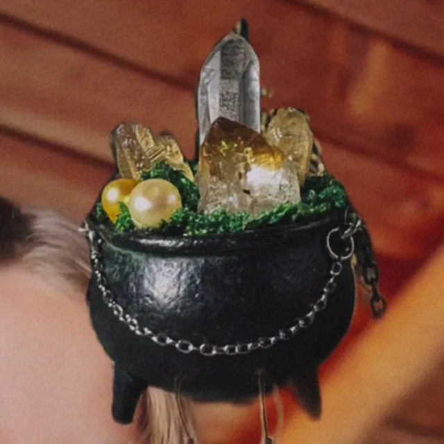 Ollita de bruja negra de porcelanicrón con cuarzos, citrinos y perlas sobre musgo, con una cadena alrededor